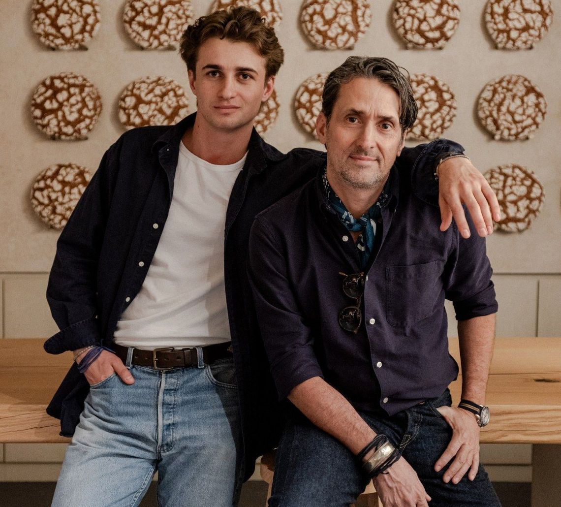 Lifestyle photography for RYE by Martin Auer featuring the founders seated before a wall of rye loaves by TRUFFL branding agency